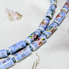 Close up of tube-shaped cloisonne design necklace - light blue