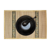 Gold edged woven placemat with black bowl and spoon