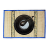 Blue edged woven placemat with black bowl and spoon