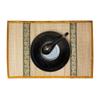 Bronze edge woven placemat with black bowl and spoon