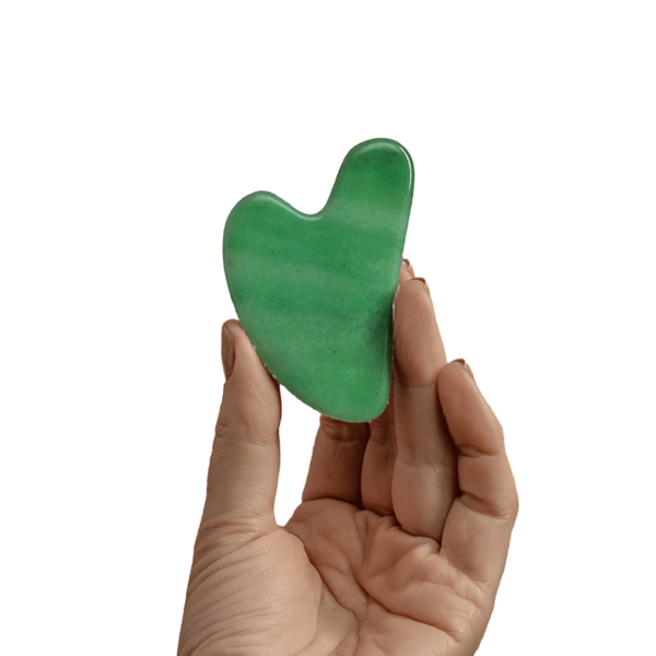 Hand holding The Jade Gua Sha Facial Lifting Tool