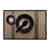 Thai-style woven placemat with black accents. Black bowl, spoon, and sauce dish on top.